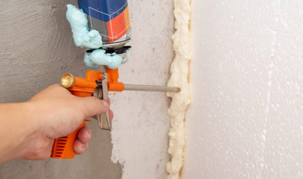 Close up image of man's hand holding air sealing gun.