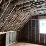 Fiberglass batt insulation installed along the sloped ceiling and walls of a residential attic by Toler Insulating.