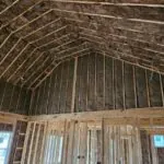 Interior framing with fiberglass insulation installed in ceiling and wall cavities by Toler Insulating.
