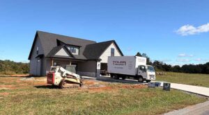 Toler Insulating truck parked outside a new home construction project in Virginia, with equipment ready for insulation installation.