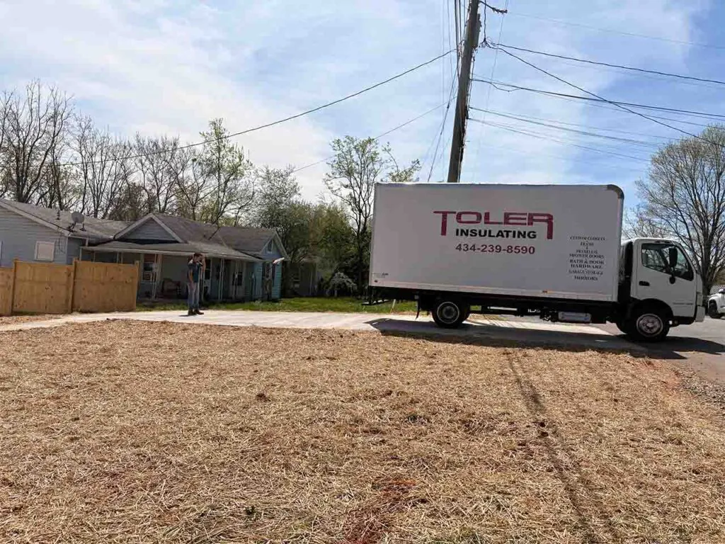 Toler Insulating branded box truck parked at a residential job site.