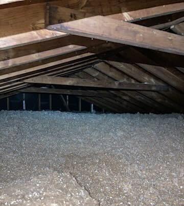 Attic floor filled with stabilized cellulose insulation between exposed roof rafters, Lynchburg, VA.