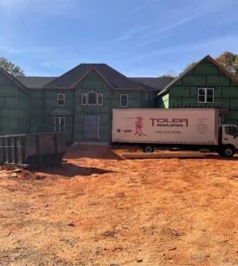 Toler Insulating work truck parked outside of new home construction.
