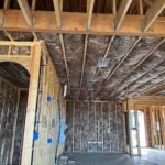 Toler Insulating fiberglass batts installed in a sloped ceiling and exterior walls beside a framed arched opening in a new construction home in Lynchburg, VA.
